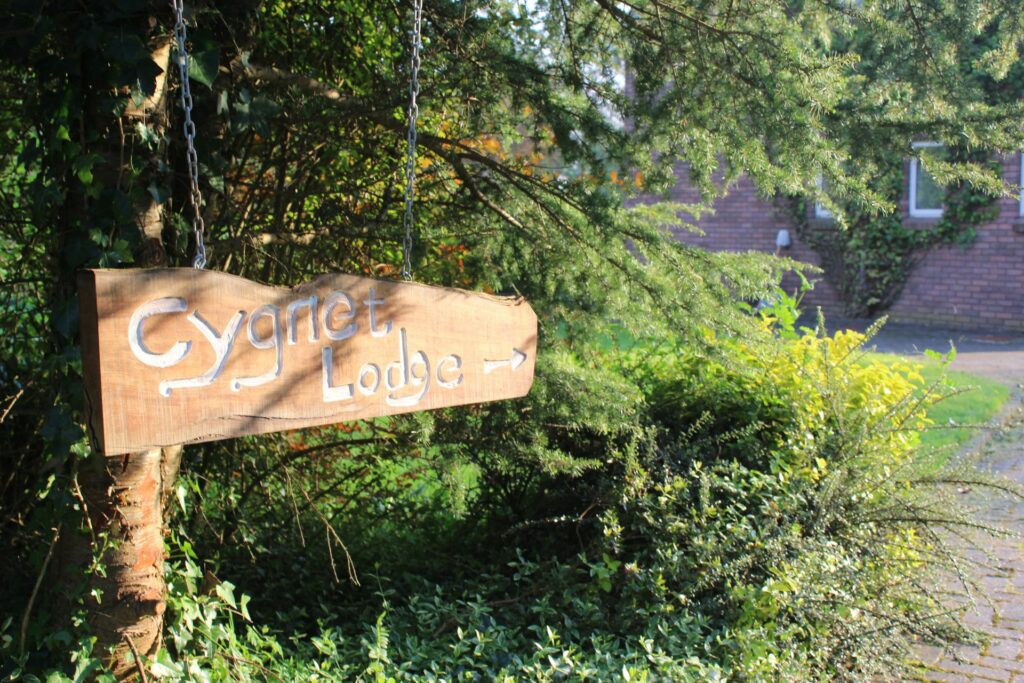 Wooden sign saying Cygnet Lodge